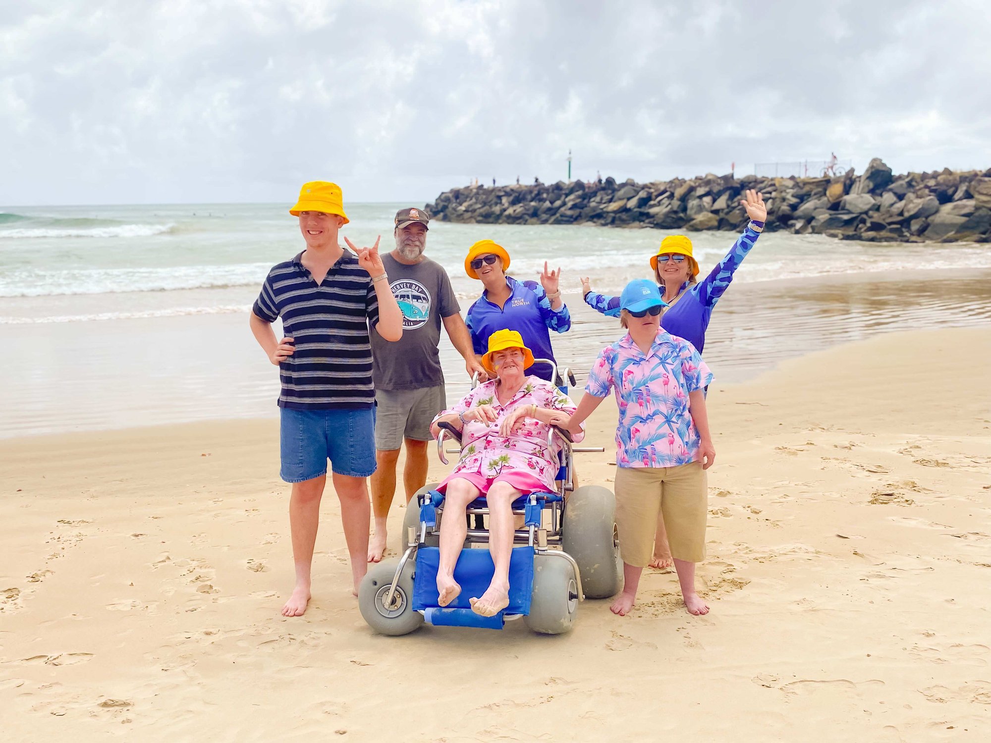 People with yellow hats together on the beach