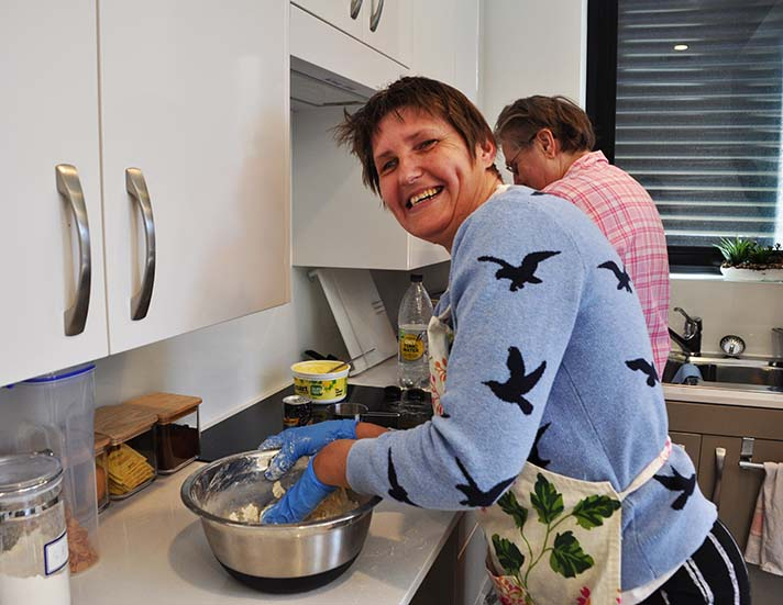 Lady at home cooking dinner in the kitchen with support worker