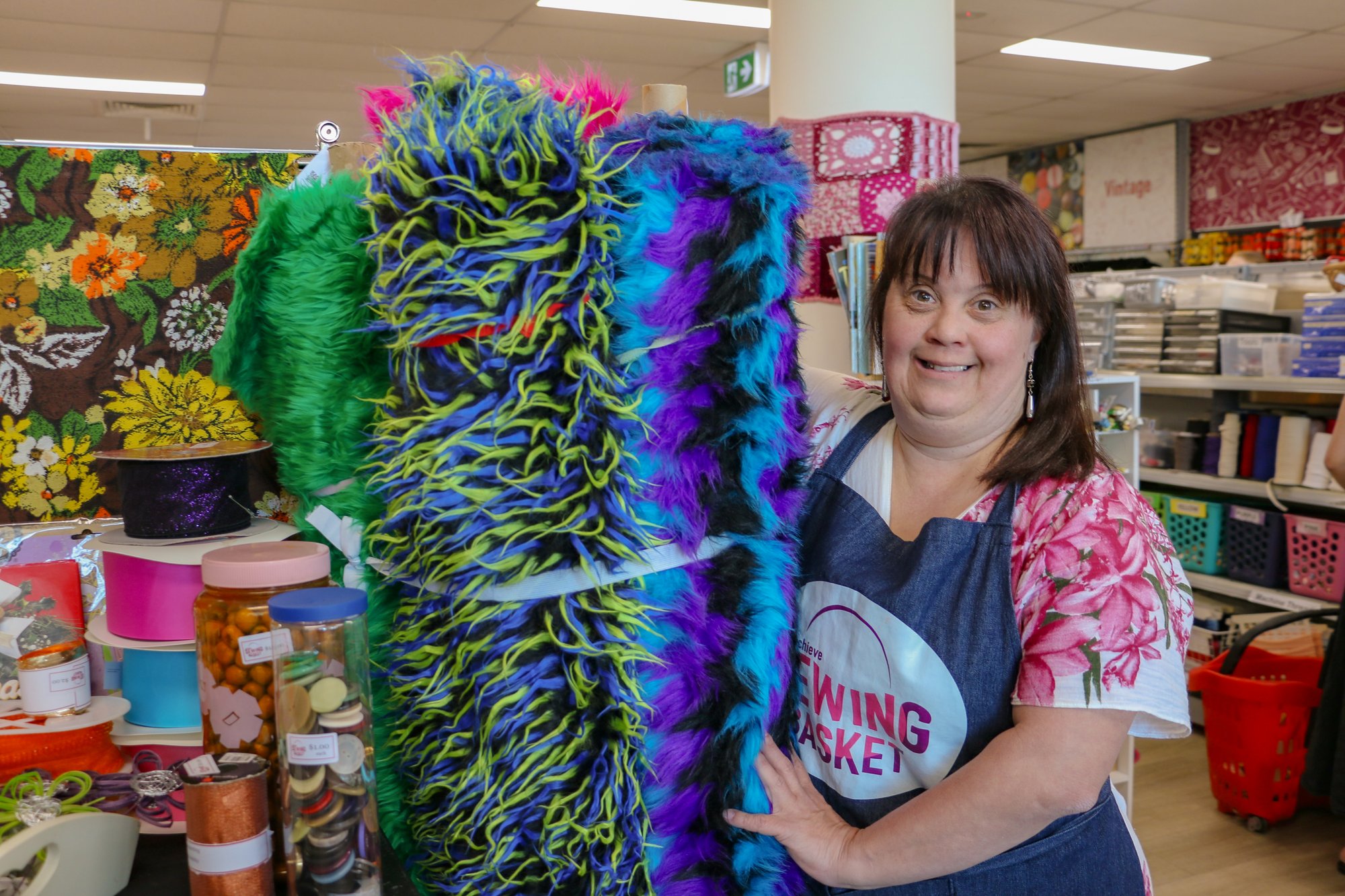 Woman with fabric in the sewing basket shop