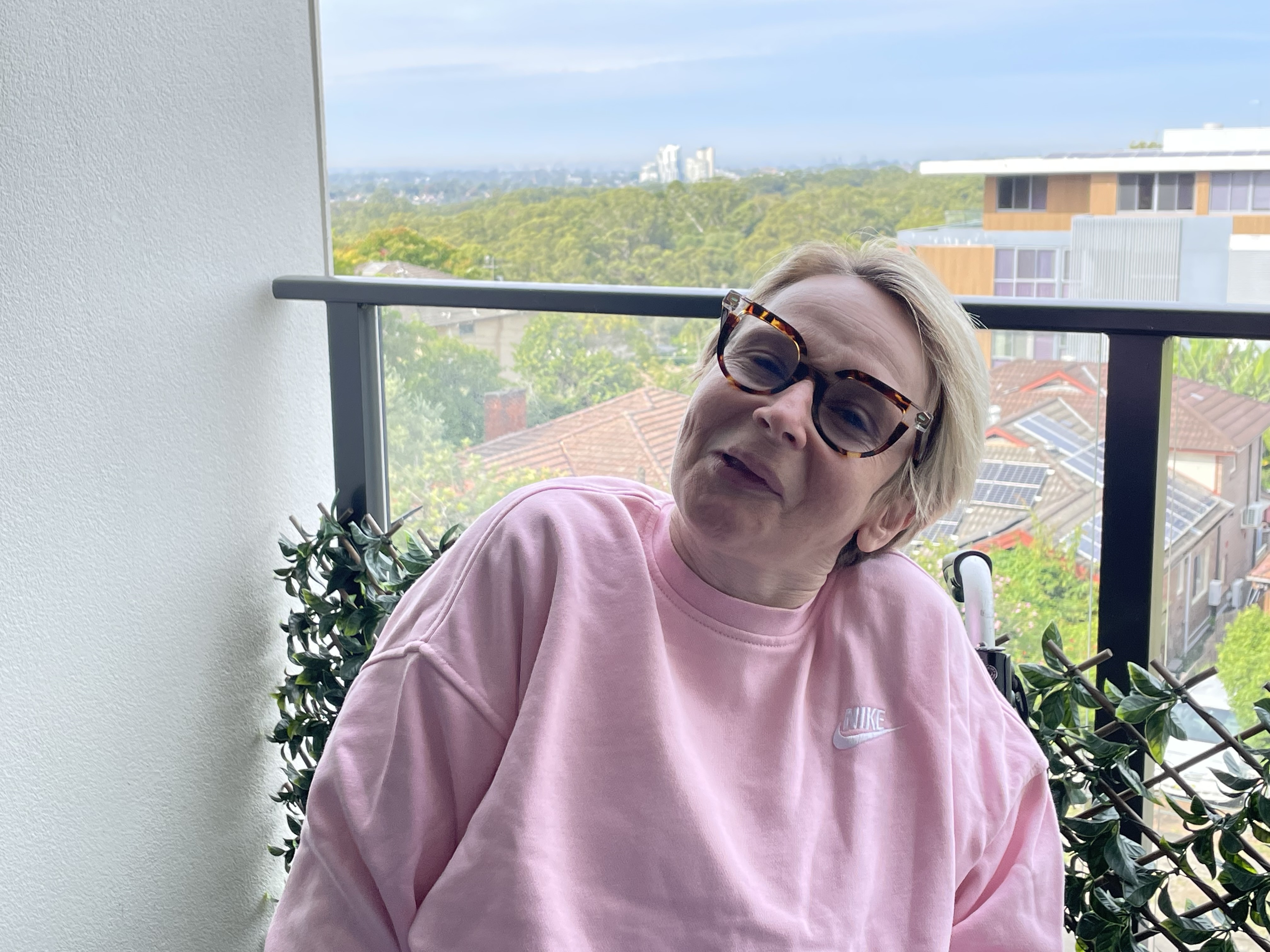 Fiona wearing a pink jumper with a natural backdrop 