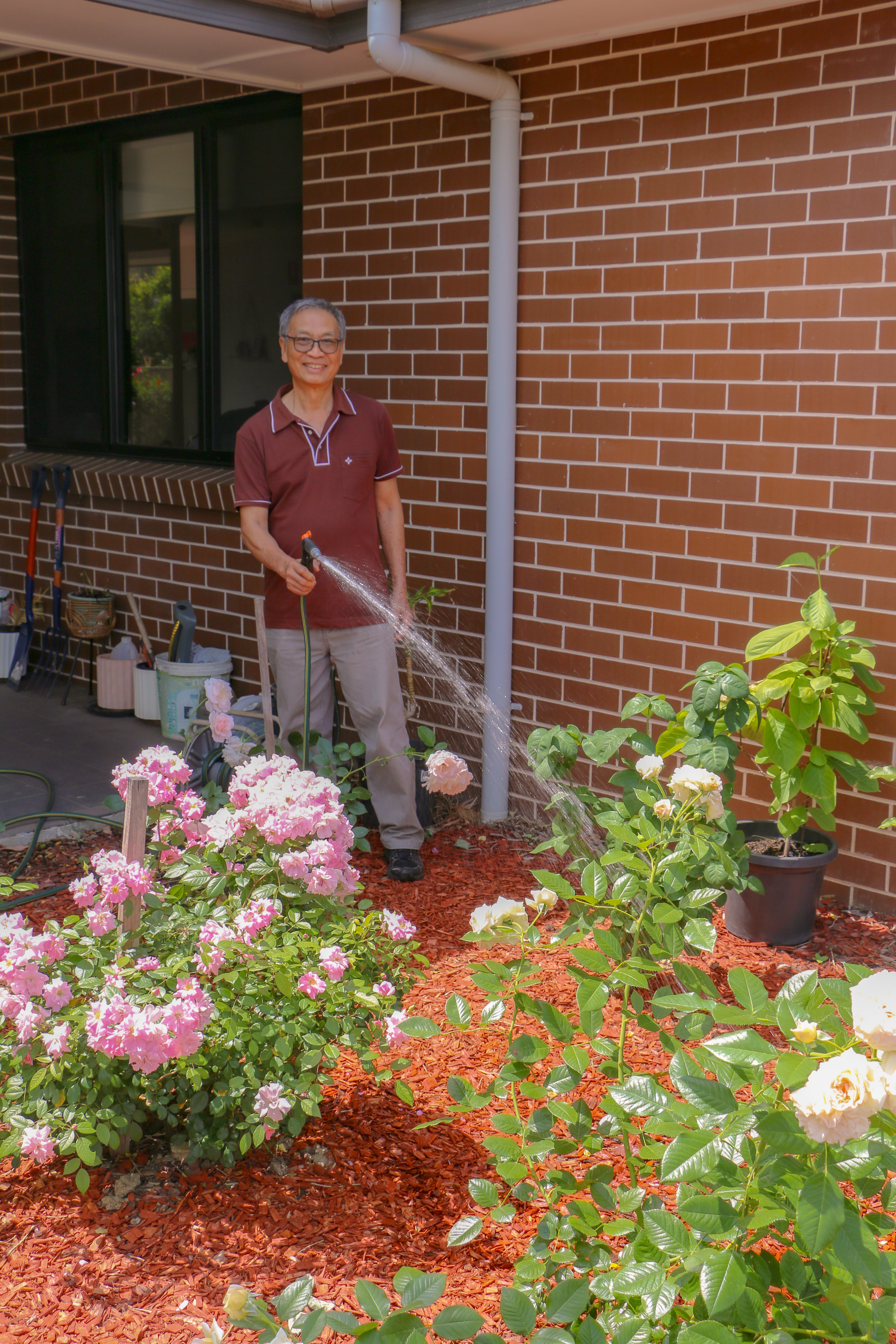 Hong watering the gardens at Guildford West