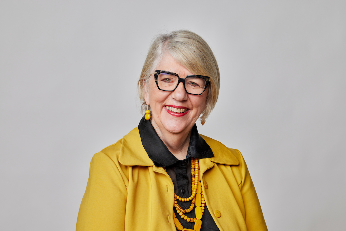 Jo-Anne Hewitt Headshot wearing a yellow jacket