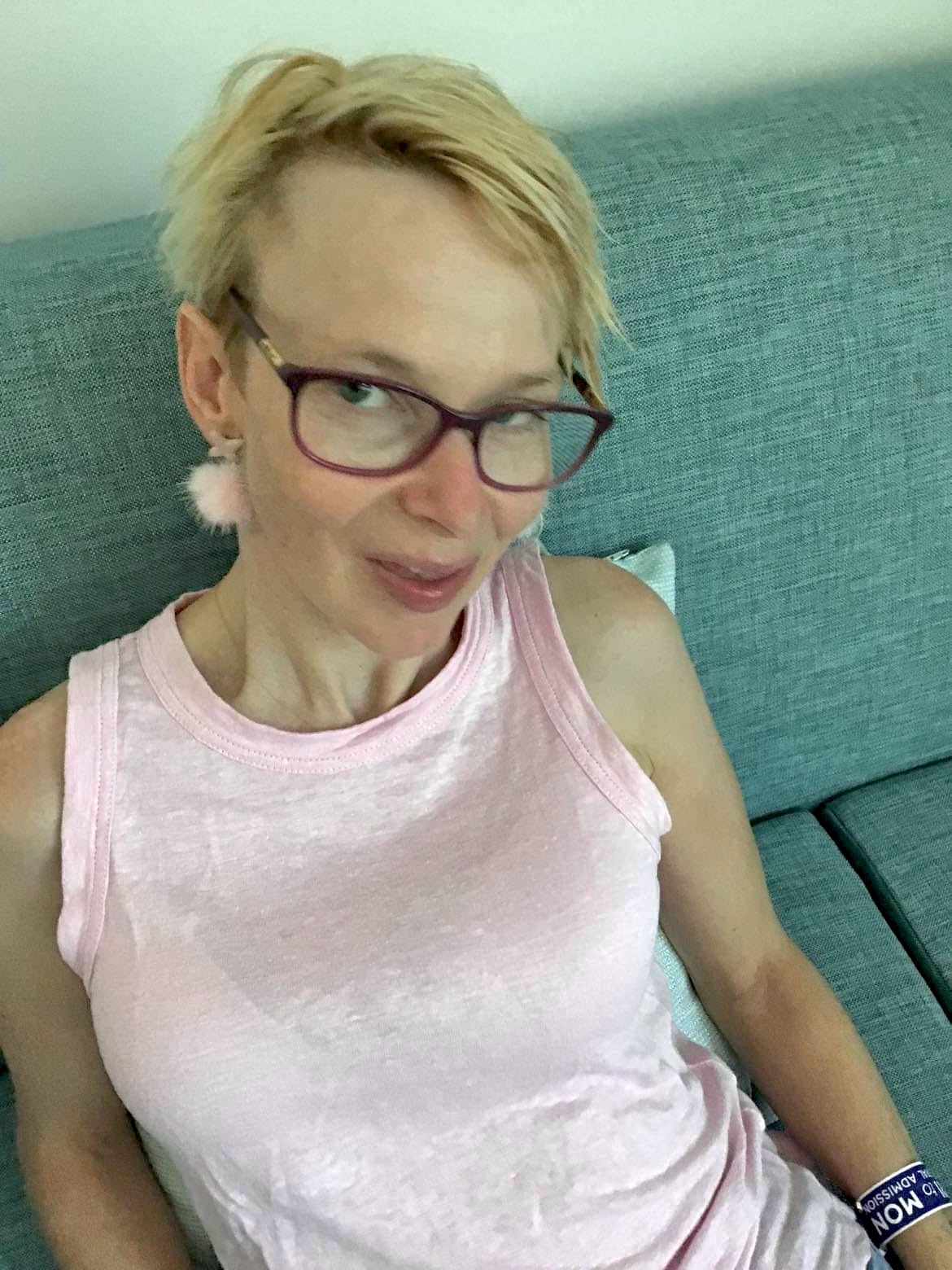 Fi Bridger at home in a pink top and pink earrings